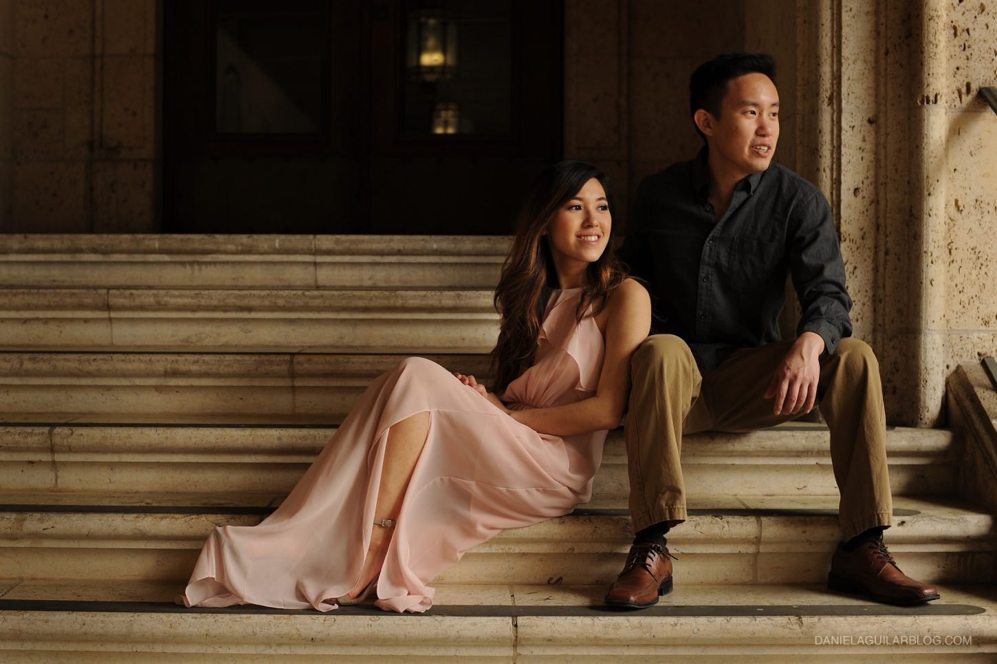 A couple is sitting in stairs of UT Austin campus for engagement photos
