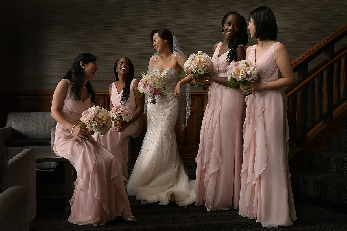 A bride is posing with four of her bridesmaids in the bar of the Lakeway Resort in Austin Texas during the formal portraits of her wedding