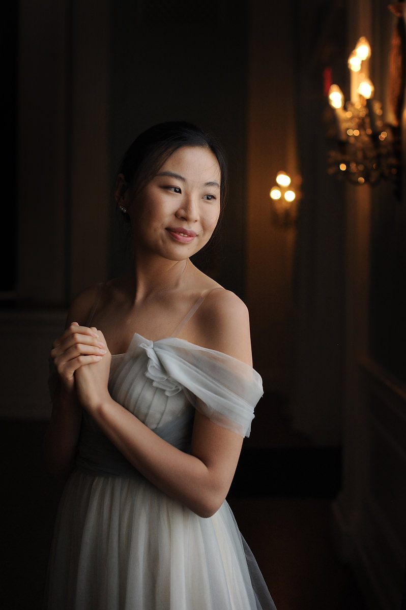 Portrait of an asian bridesmaid posing next to a window in The Mansion in Austin TX