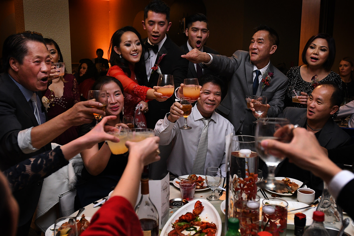 A large group of family members toast for the wedding of a vietnamese couple in Houston TX