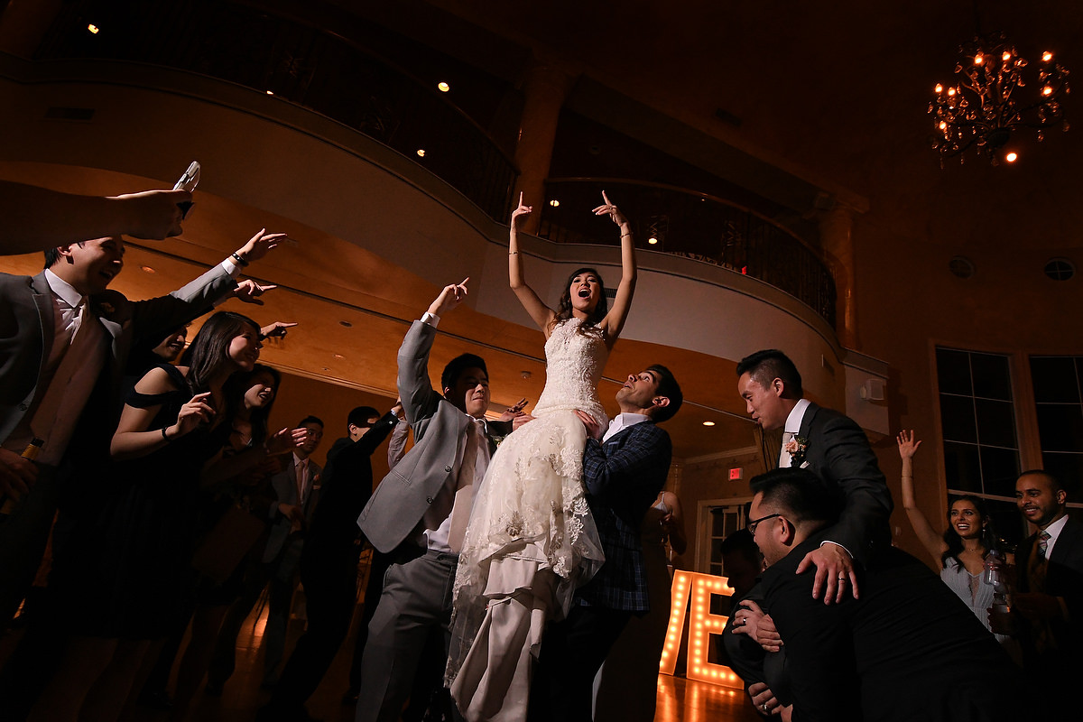 A bride is lifted up in arms during her reception party in Chateau Polonez in Houston TX