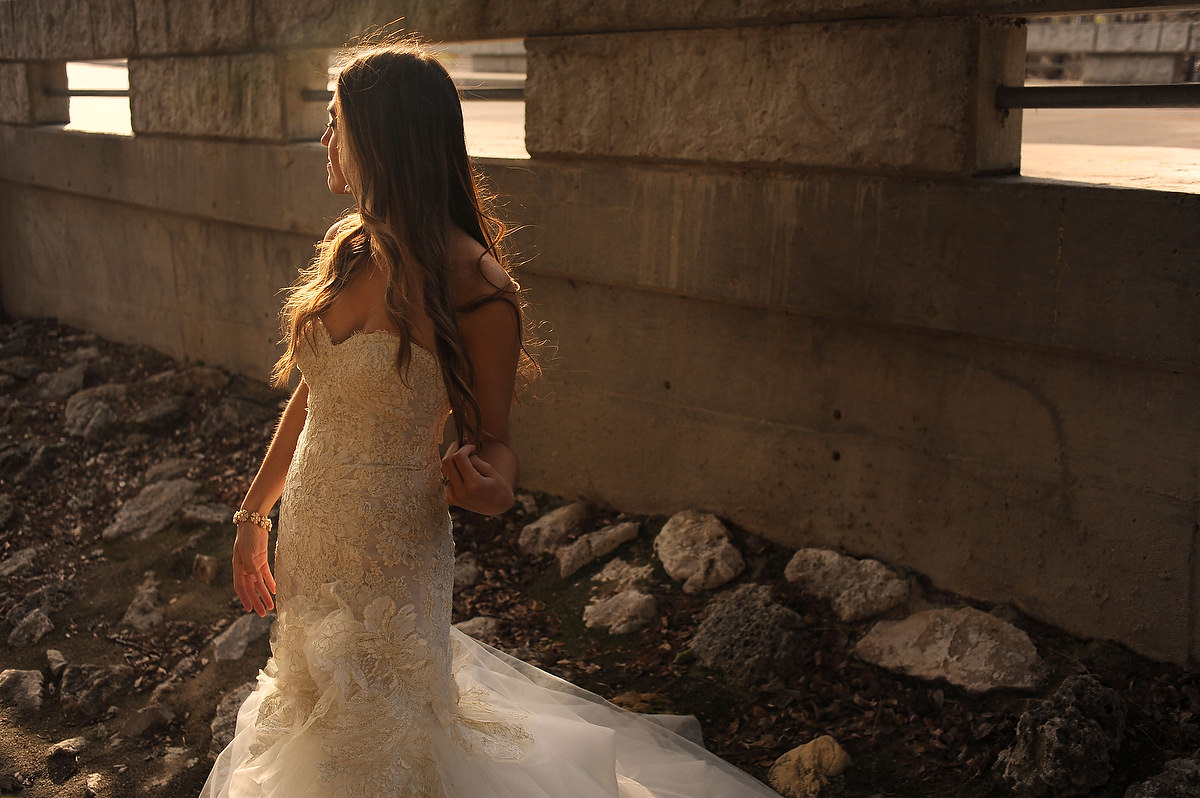 a bride is posing during the golden hour in a bridge in gruene tx