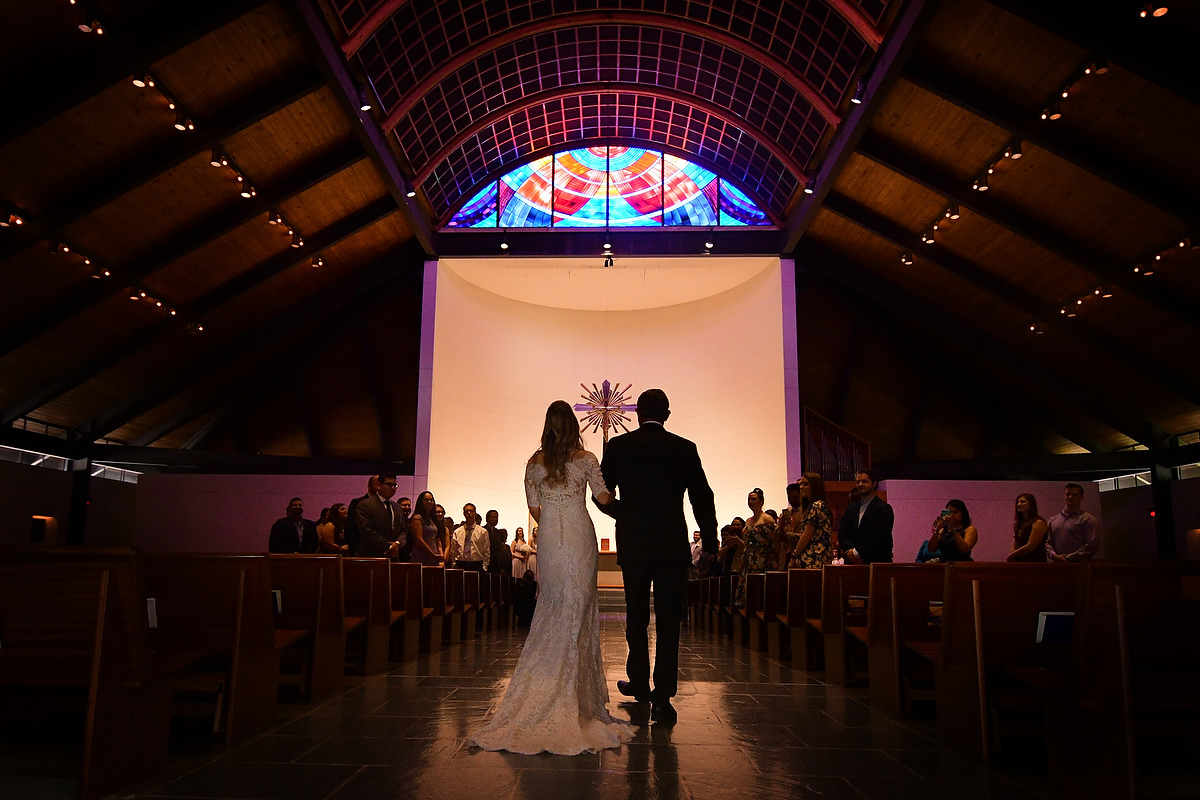 a bride is about to walk down the isle of the St Cecilia catholic church in houston texas