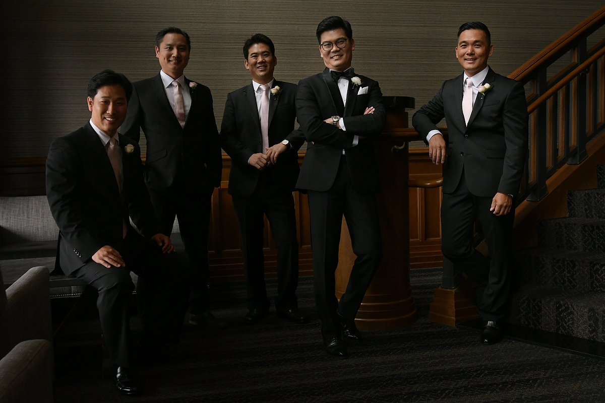a group of asian groomsmen pose candidly for their portrait in lakeway resort in austin texas