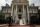 a bride is walking towards the entrance of the mansion in austin texas