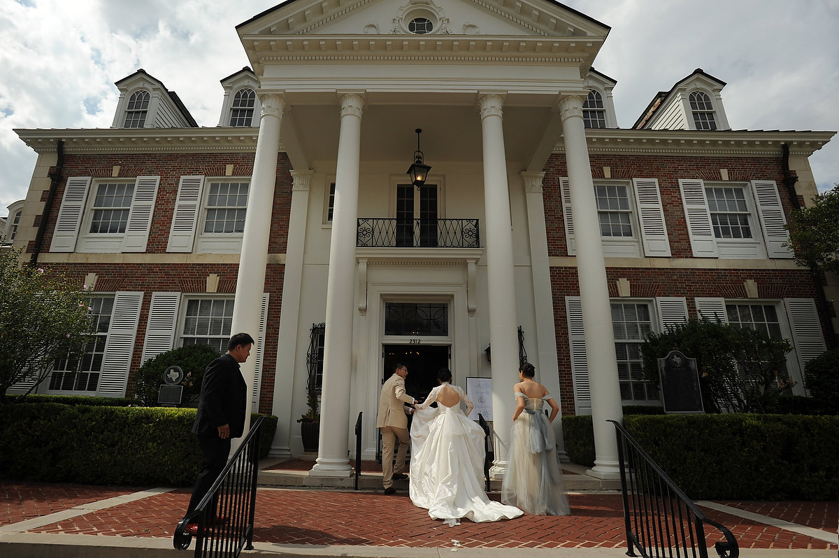 a bride is walking towards the entrance of the mansion in austin texas